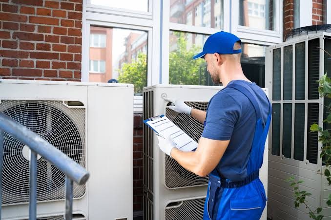 HVAC technician reviewing outdoor condenser units on a clipboard