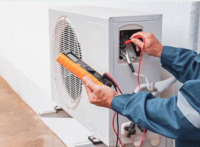 Technician testing an outdoor AC unit with a digital multimeter